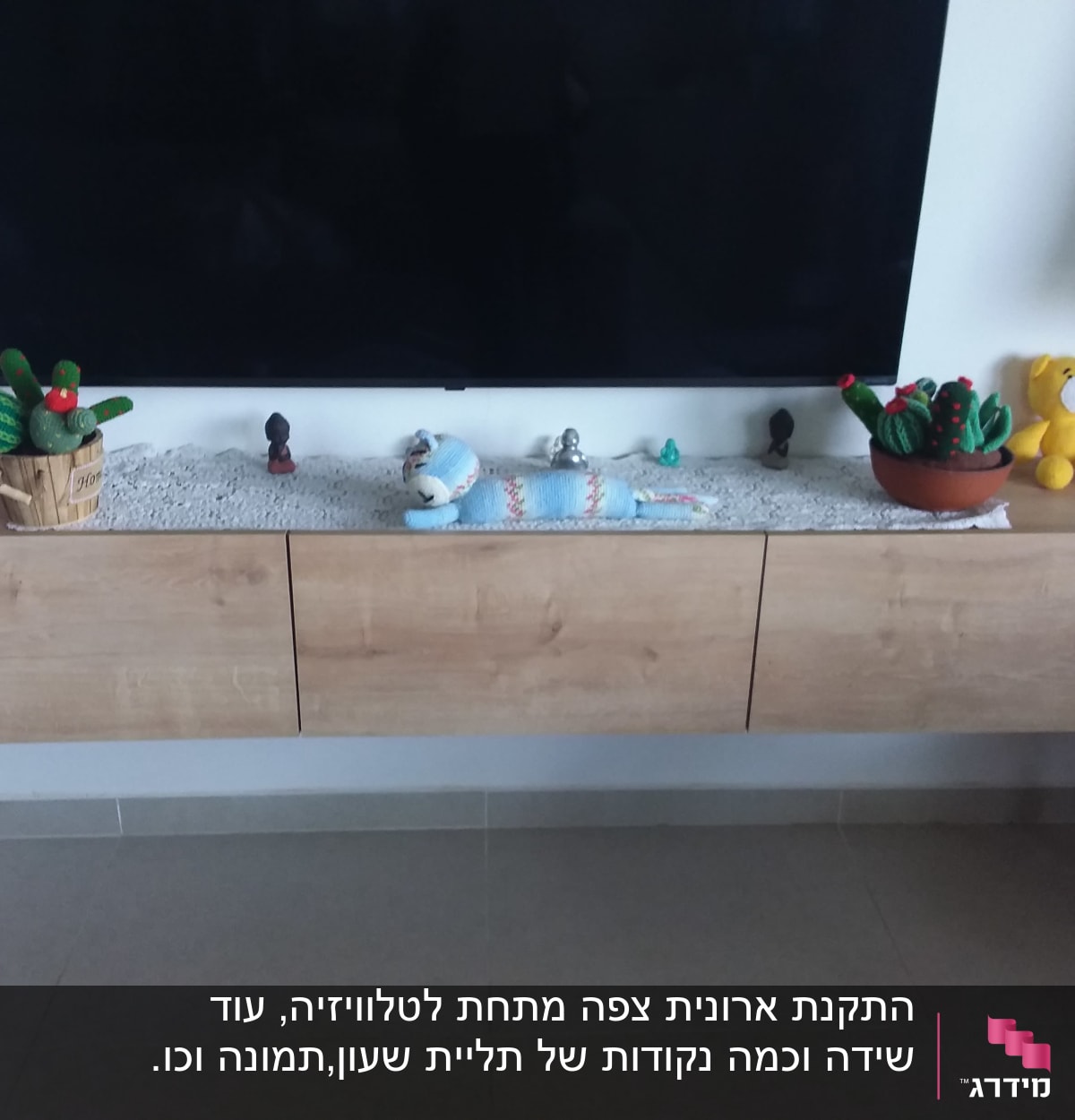 ארונית עץ תלויה על הקיר מתחת לטלוויזיה